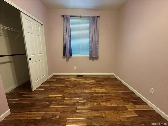 a view of a room with wooden floor and cabinet
