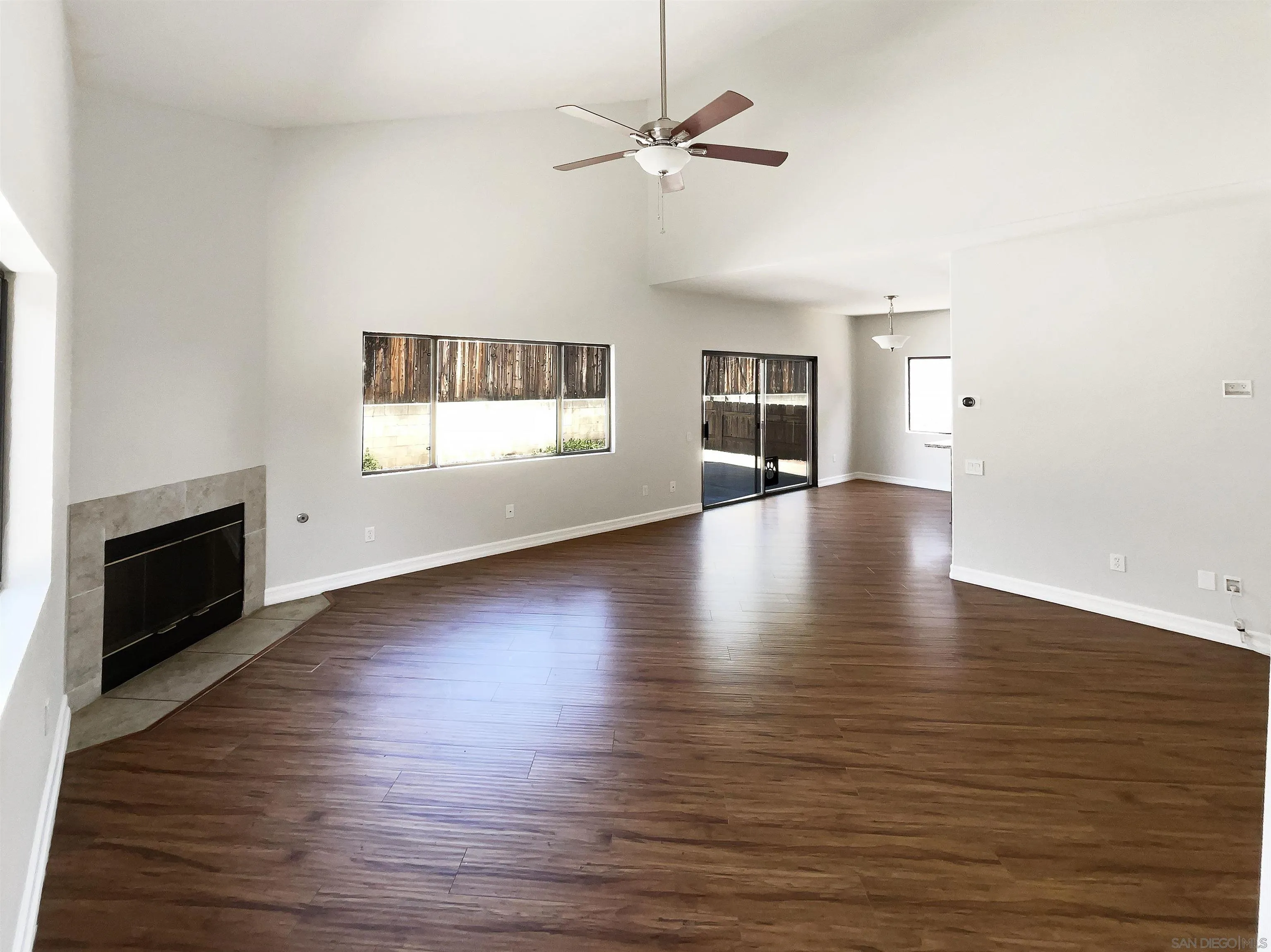 7922 Sunset Terrace Lemon Grove, CA 91945 - Photo 3 of 22 an empty room with wooden floor fireplace and windows