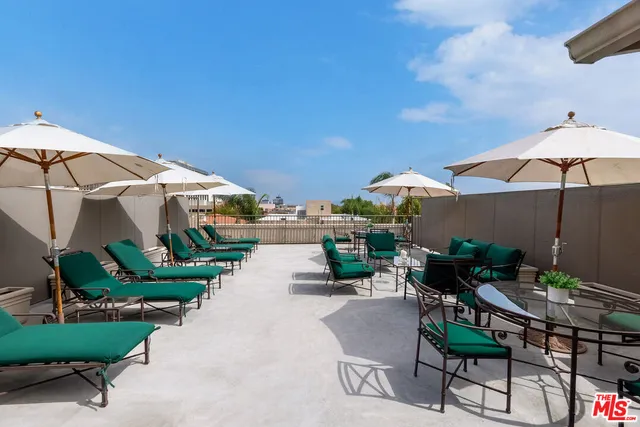 a view of a patio with furniture and a table and chairs under an umbrella