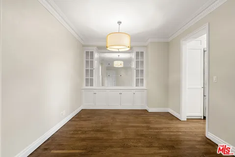 a view of a room with wooden floor and white walls