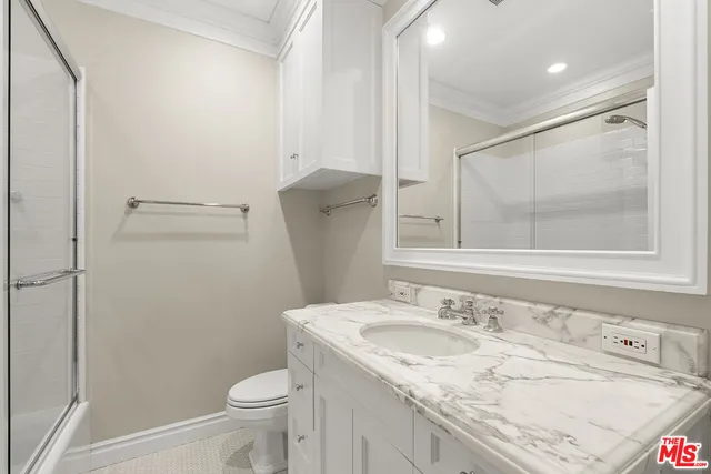 a bathroom with a sink toilet vanity and shower