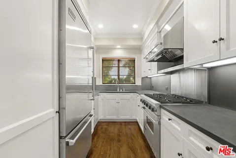 a kitchen with stainless steel appliances granite countertop a sink and a stove