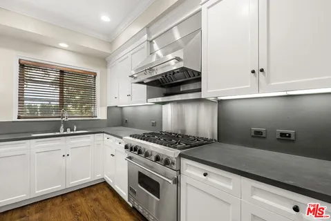 a kitchen with granite countertop a stove and a sink