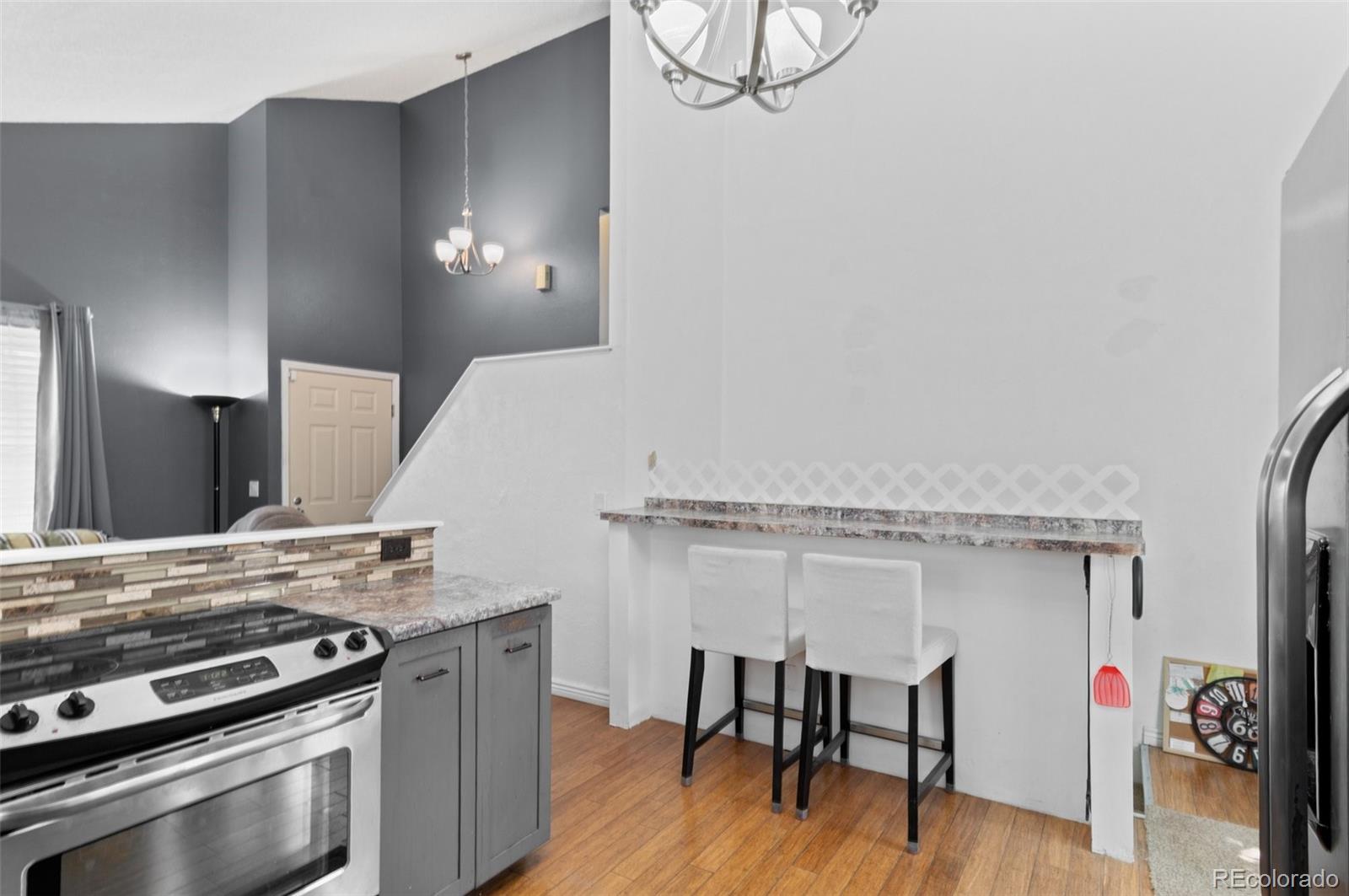 9648 Lane Street Thornton, CO 80260 - Photo 12 of 27 a kitchen with a stove and a wooden floor