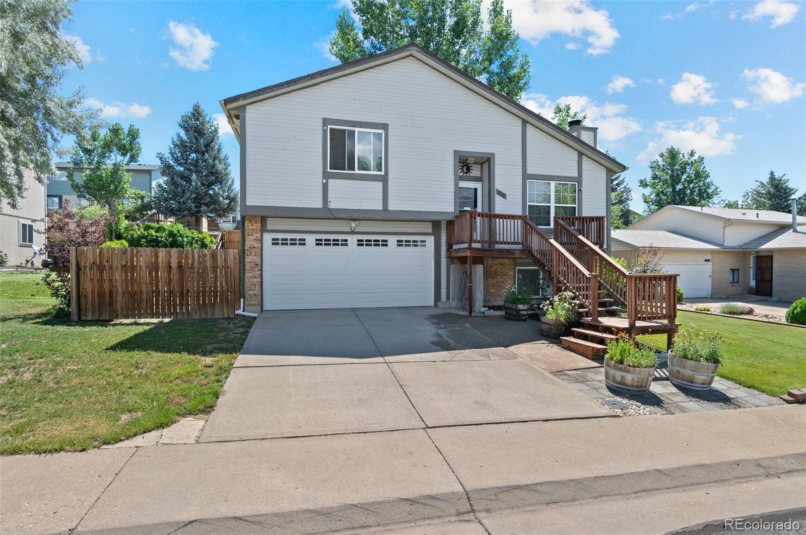 9648 Lane Street Thornton, CO 80260 - Photo 2 of 27 a front view of a house with a yard and outdoor seating