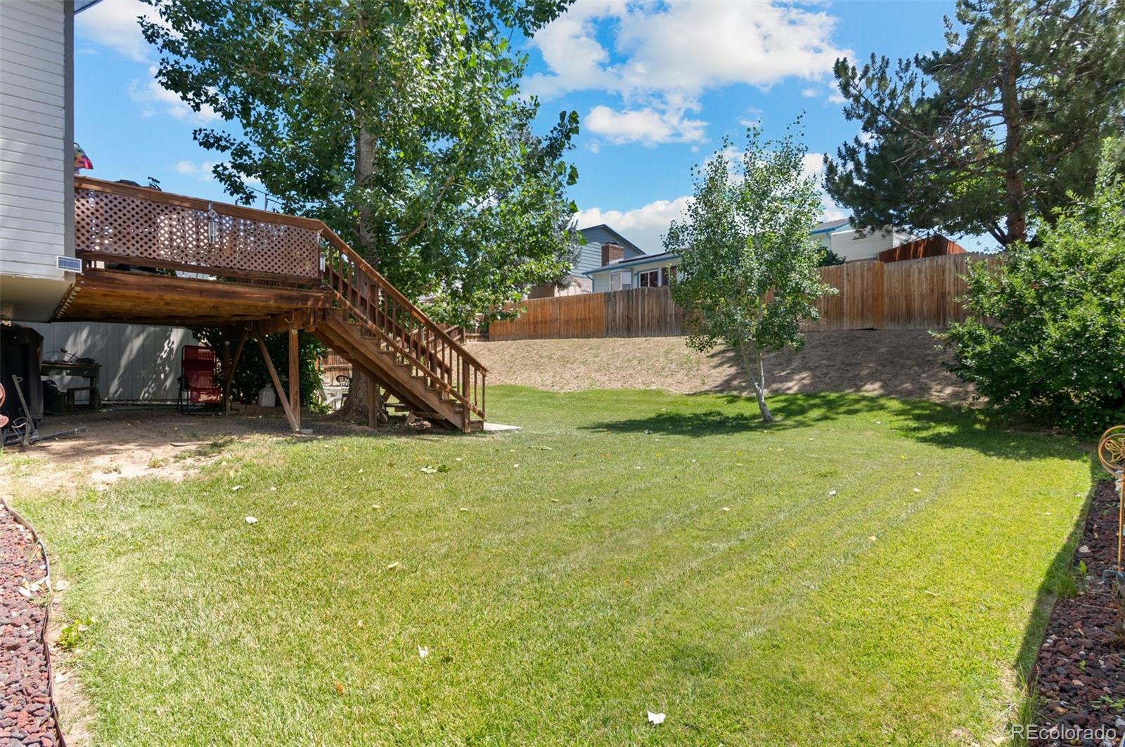 9648 Lane Street Thornton, CO 80260 - Photo 22 of 27 a view of a backyard with table and chairs and potted plants