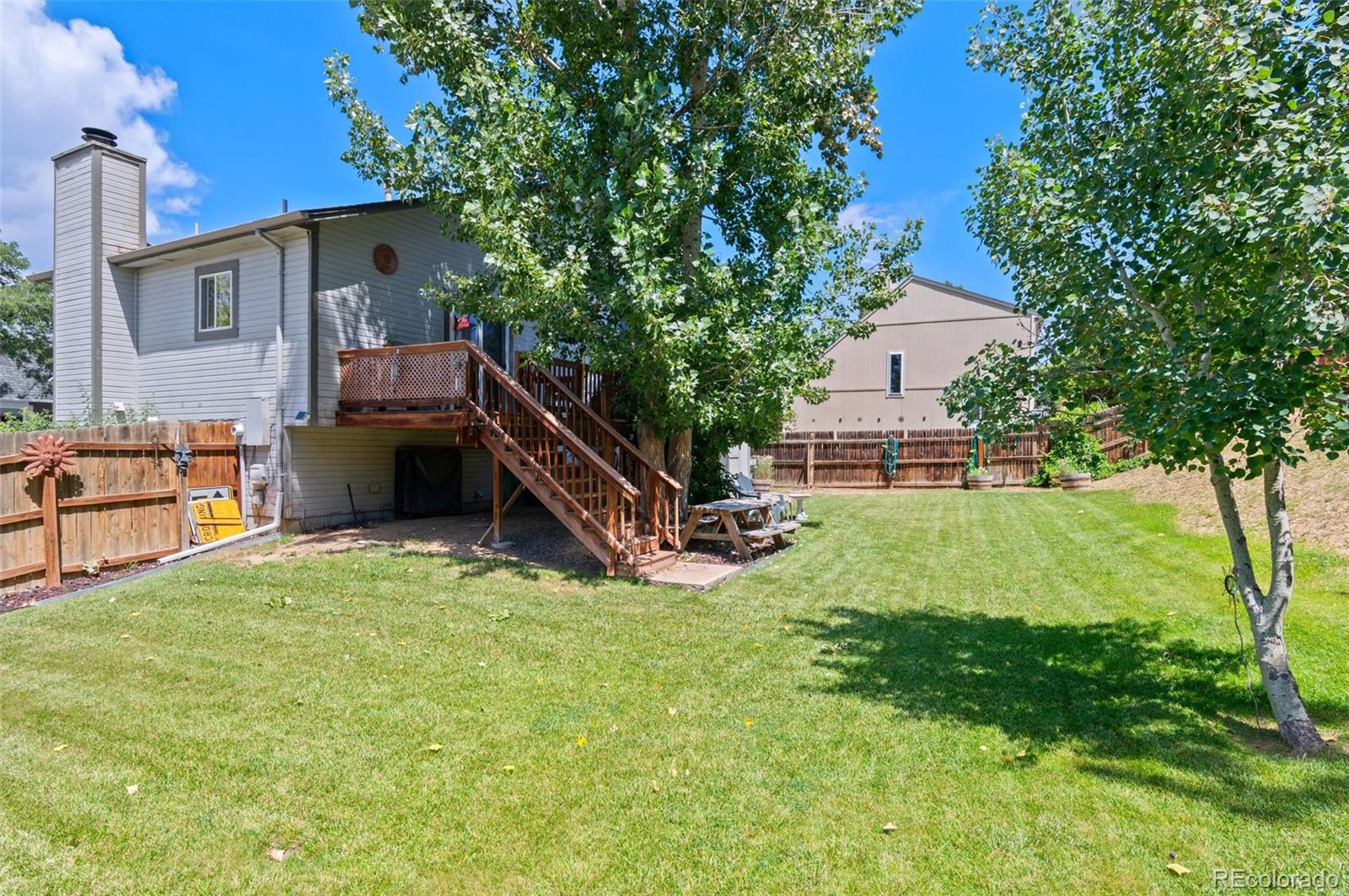 9648 Lane Street Thornton, CO 80260 - Photo 23 of 27 a view of backyard with barbeque grill and a large tree