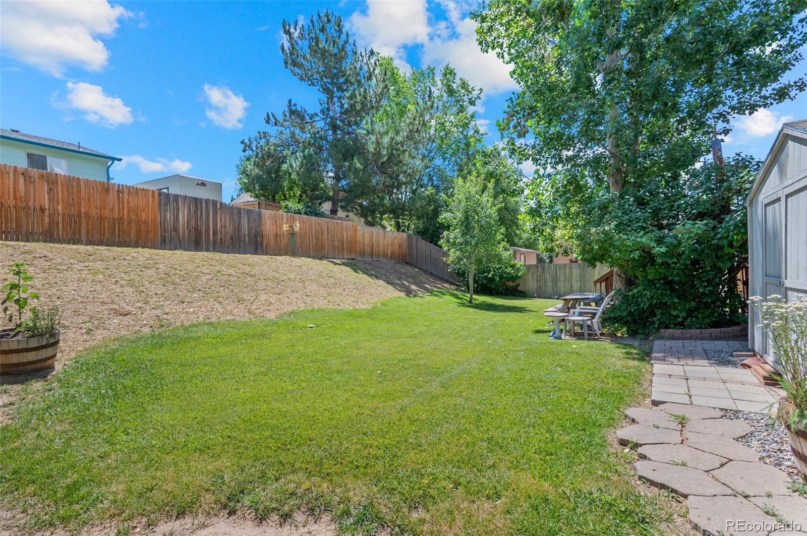 9648 Lane Street Thornton, CO 80260 - Photo 25 of 27 a view of a backyard with wooden fence and large trees