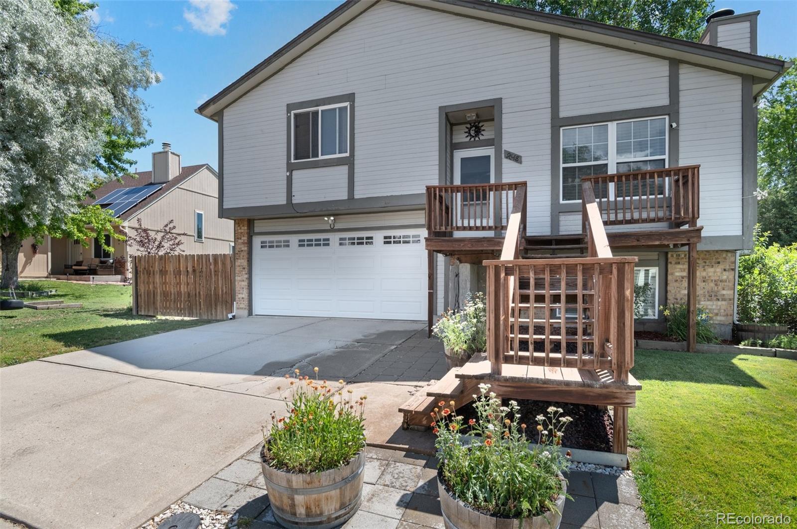 9648 Lane Street Thornton, CO 80260 - Photo 3 of 27 a front view of a house with garden