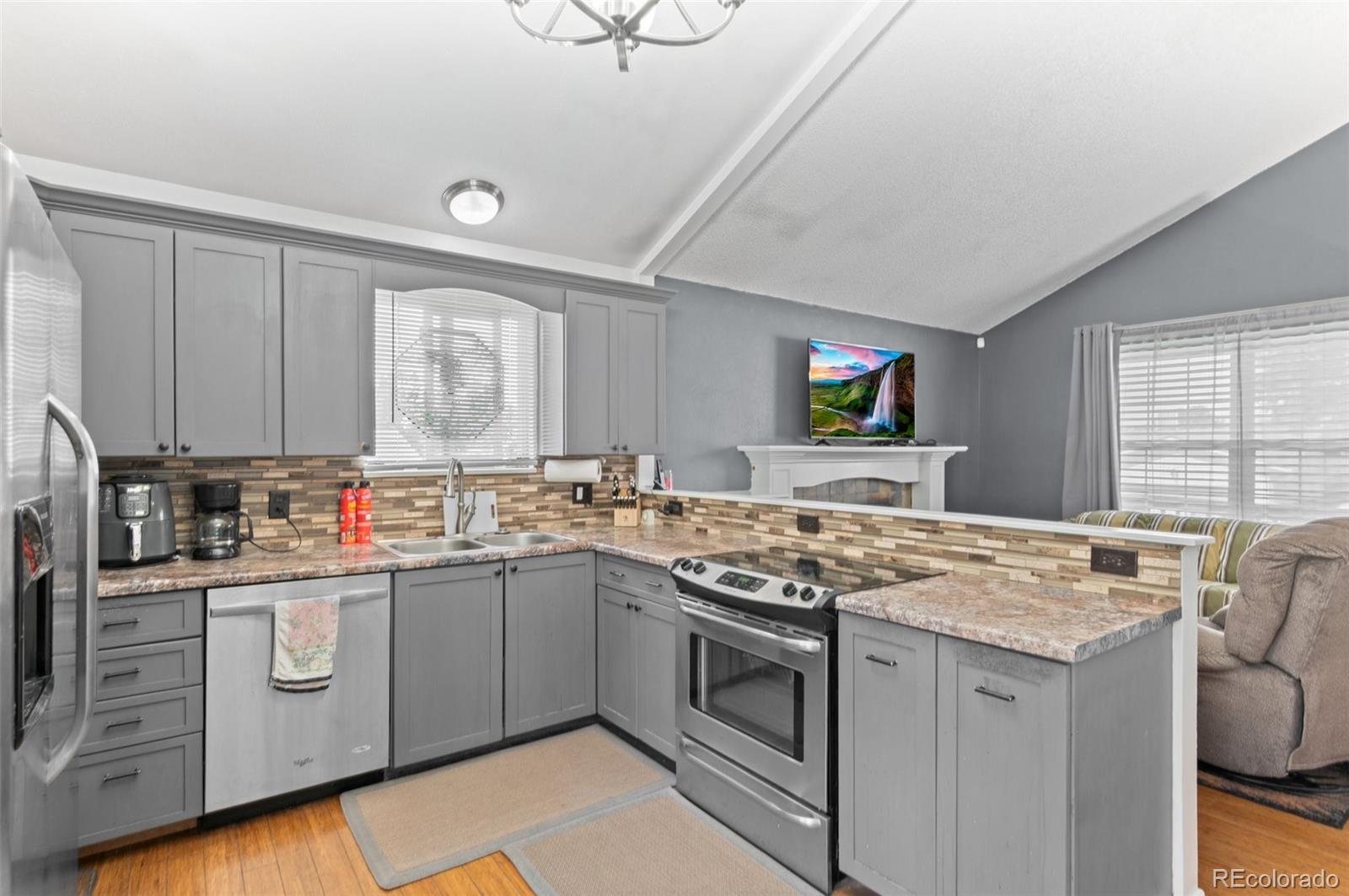 9648 Lane Street Thornton, CO 80260 - Photo 8 of 27 a kitchen with stainless steel appliances granite countertop a stove sink and cabinets