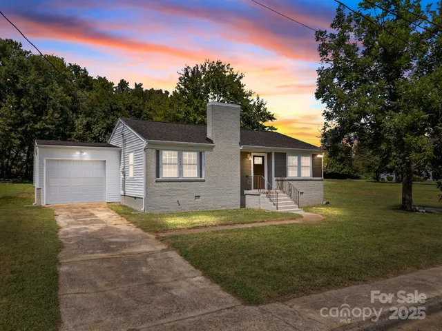 a view of a house with a big yard and large tree