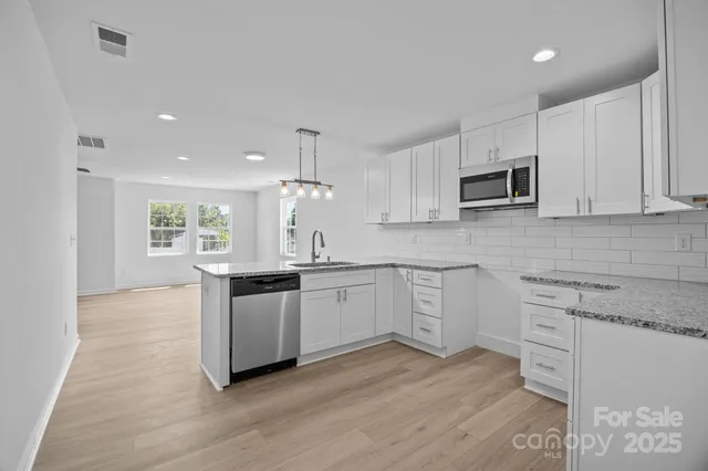 a large kitchen with cabinets wooden floor and stainless steel appliances