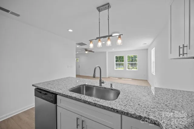 a kitchen with a sink and chandelier