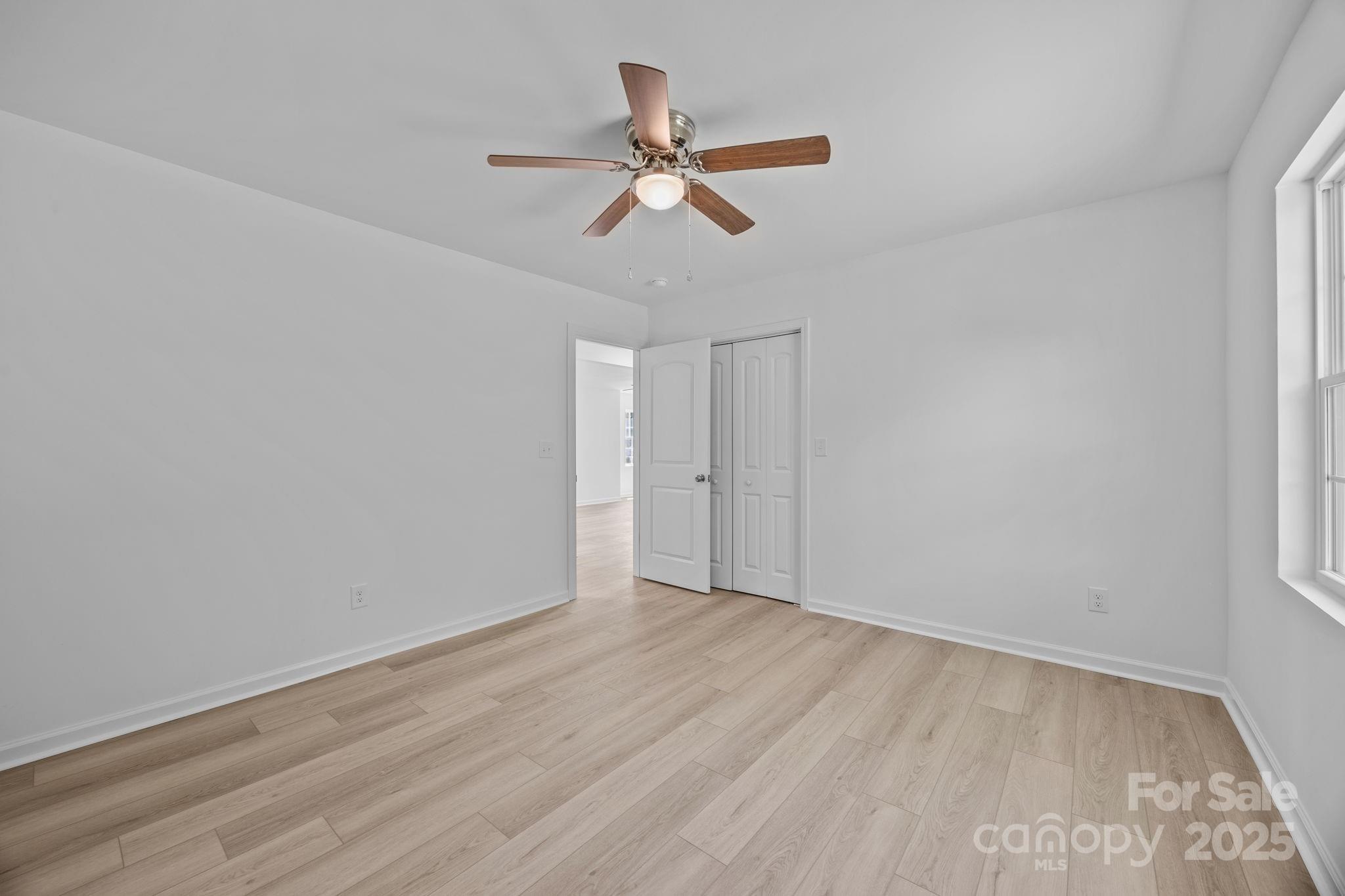 409 Shaver Street Salisbury, NC 28144 - Photo 23 of 39 an empty room with wooden floor ceiling fan and windows