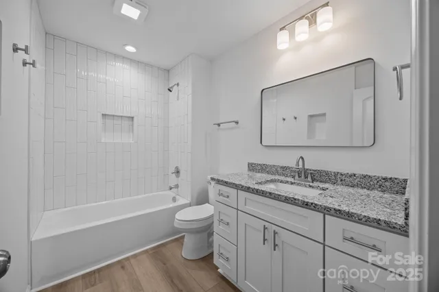 a bathroom with a granite countertop sink toilet and shower