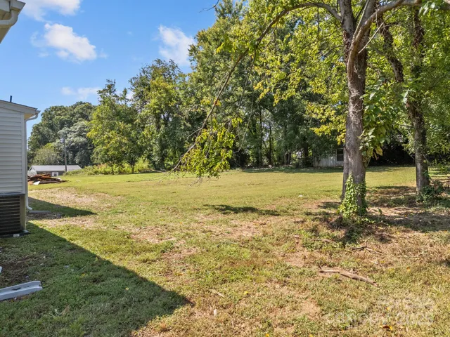 a view of a yard with wooden fence