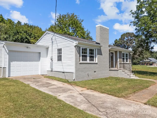 a view of a house with a yard and garage