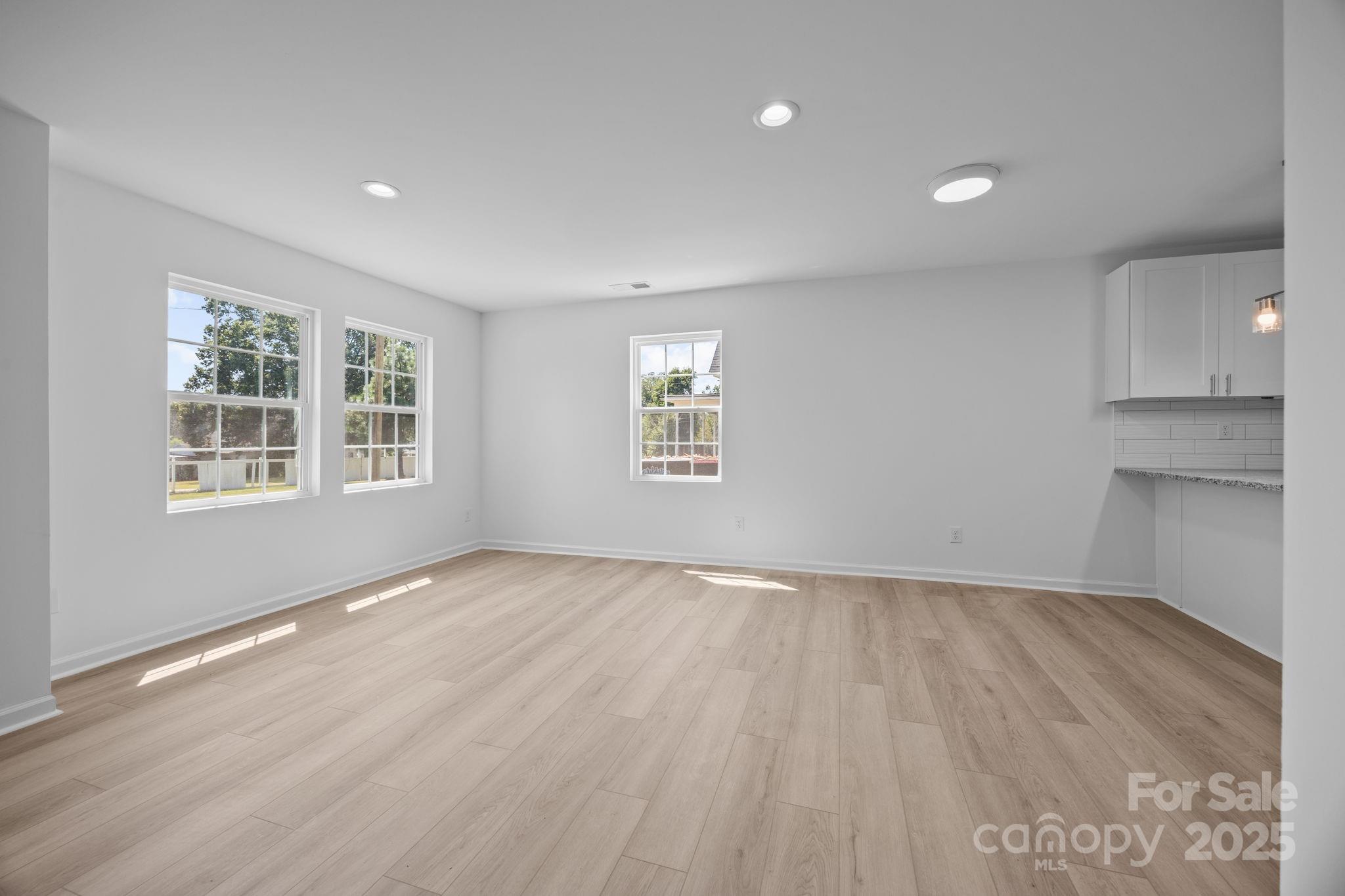409 Shaver Street Salisbury, NC 28144 - Photo 10 of 39 an empty room with wooden floor and windows