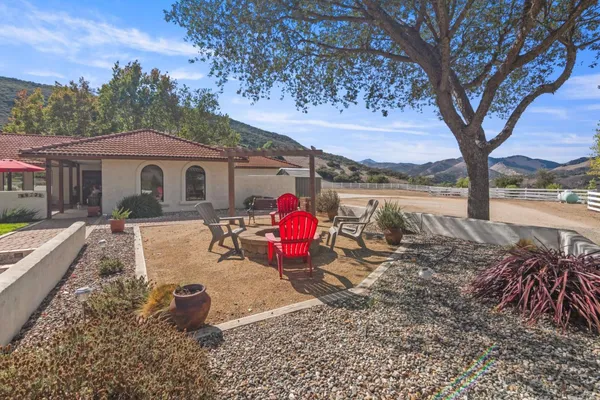 a view of a house with pool and sitting area