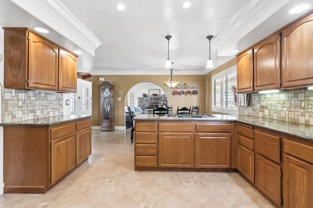 a kitchen with stainless steel appliances granite countertop a sink and a window