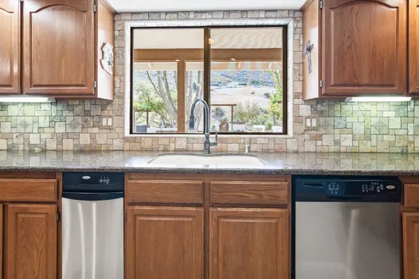 a kitchen with granite countertop white cabinets and white appliances