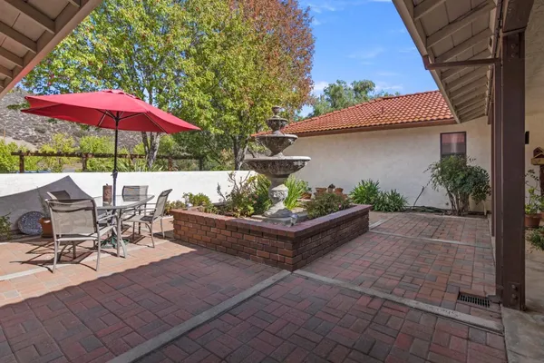 a view of patio with chairs and table under an umbrella
