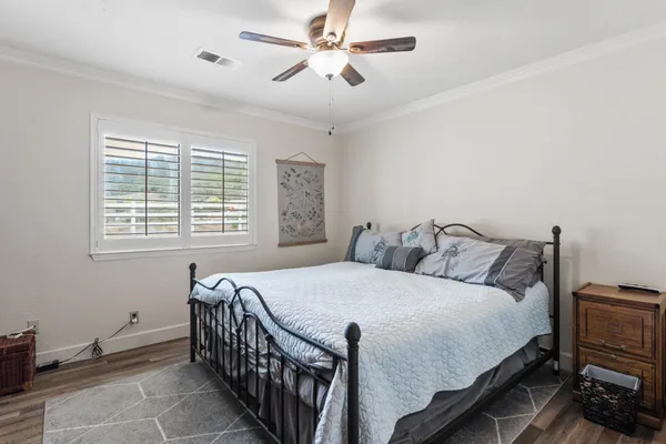 a bedroom with a bed lamps and a large mirror on the dresser