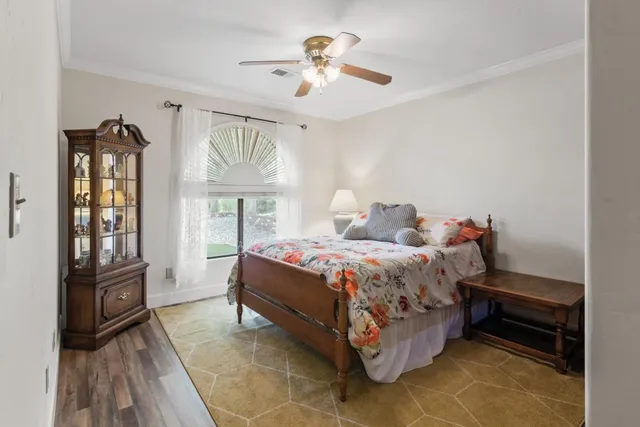 an empty room with wooden floor fan and windows
