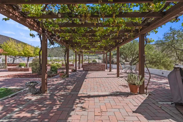 a view of a patio with table and chairs with wooden floor and fence