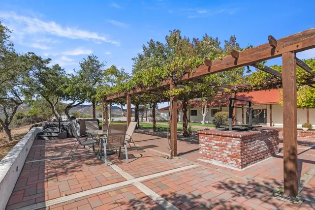 a front view of a house with a yard and mountain view in front of it