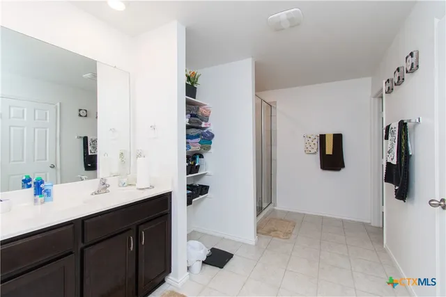 a bathroom with a sink vanity and shower