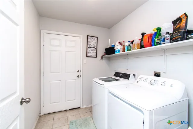 a utility room with dryer washer and shoe rack