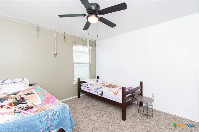 a bedroom with a bed and a ceiling fan
