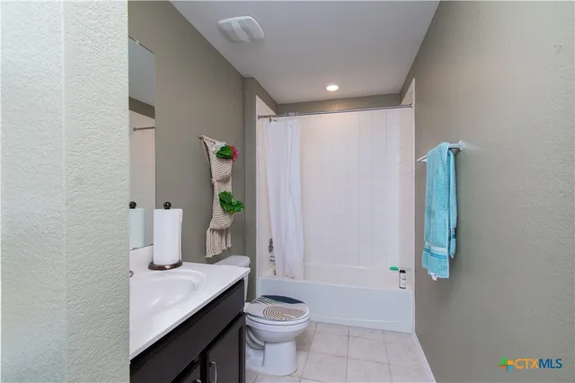 a bathroom with a granite countertop sink a toilet and shower