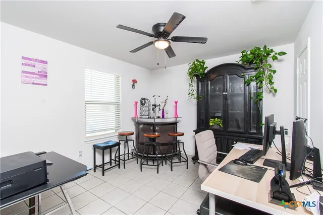 a work room with furniture and a potted plant