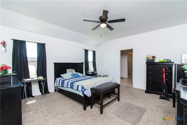 a bedroom with a bed and a ceiling fan