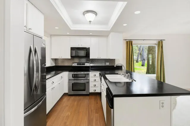 a kitchen with granite countertop a sink appliances and cabinets