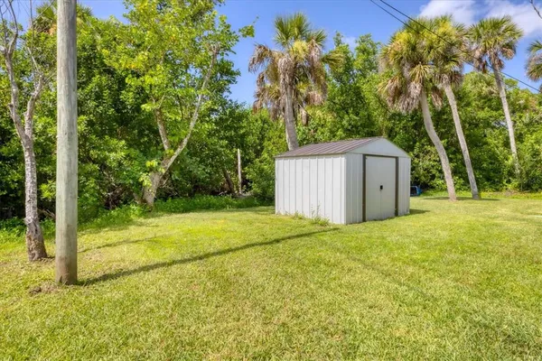 a backyard of a house with plants and large trees