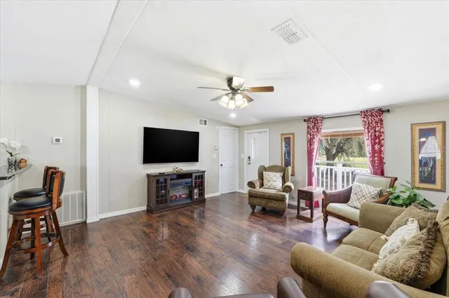 a kitchen with stainless steel appliances granite countertop a stove top oven a sink a dining table and chairs with wooden floor