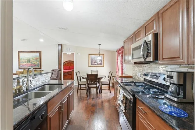 a kitchen with sink a stove and cabinets