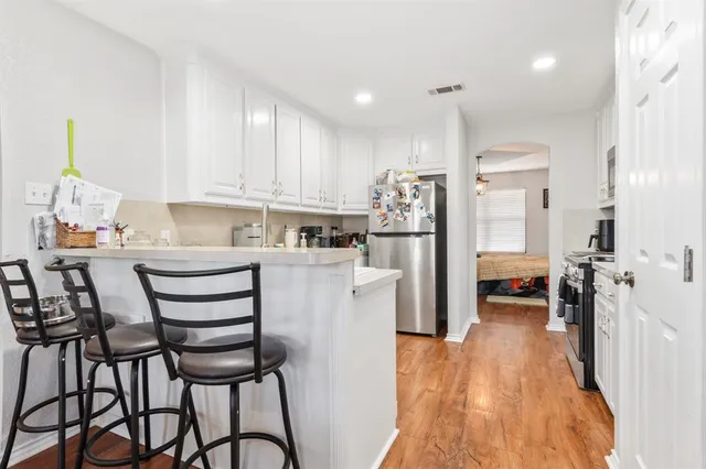 a kitchen with stainless steel appliances a refrigerator and a stove top oven