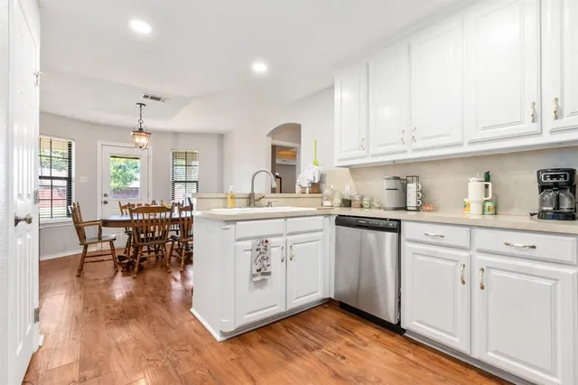 a kitchen with white cabinets and sink