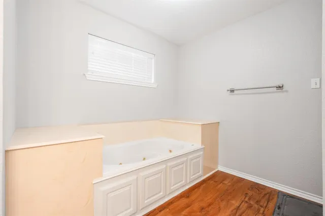 a bathroom with a bathtub and a window