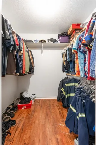 a view of walk in closet with clothes and shoes