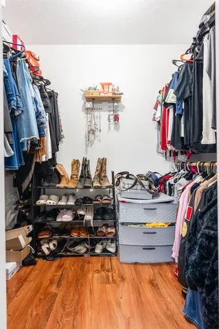 a view of walk in closet with clothes and shoes