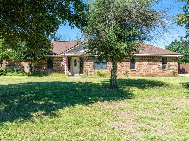 a front view of house with yard and green space