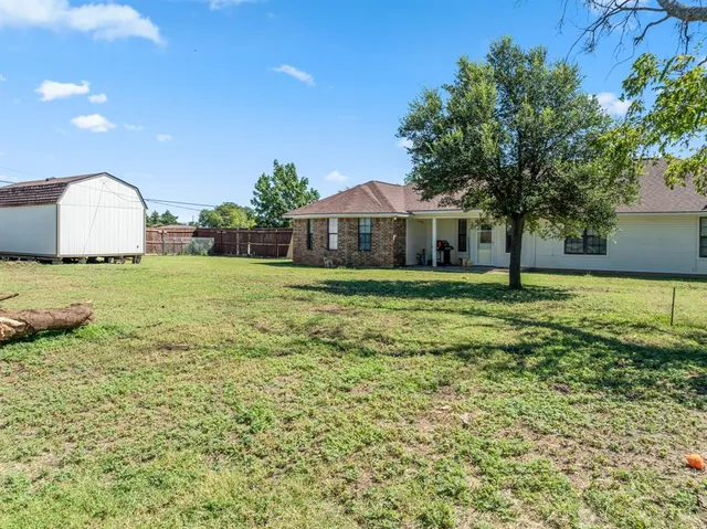 a view of a big yard with a house and large trees