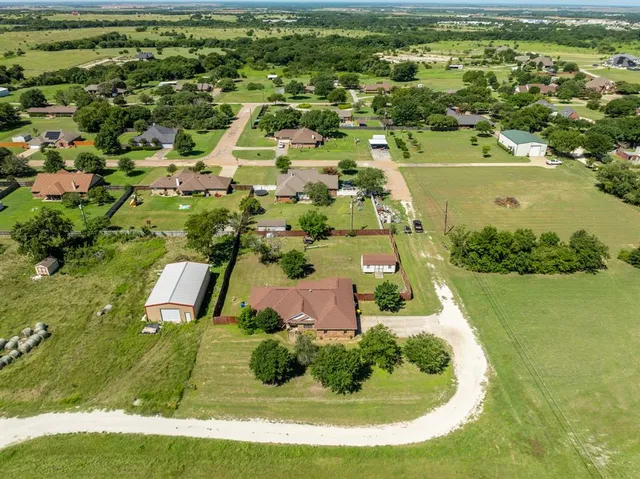 an aerial view of residential houses with outdoor space and trees