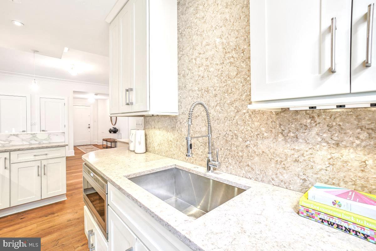 1910 Kalorama Road Northwest, Unit 403 Washington, DC 20009 - Photo 14 of 52 a kitchen with granite countertop a sink a stove and a microwave