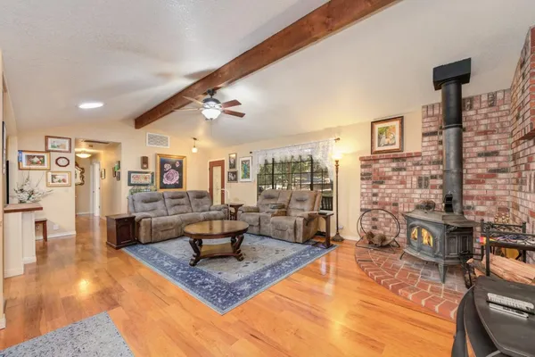 a living room with furniture and a dining table with wooden floor